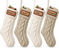 Four cream and beige cable knit Christmas stockings with example name cards