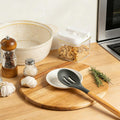 White spiral glazed ceramic spoon rest on a kitchen counter; utensil and accessories not included