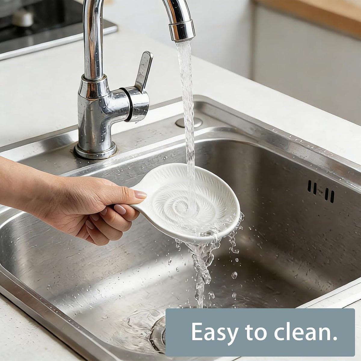 White ceramic spoon rest being rinsed in a sink